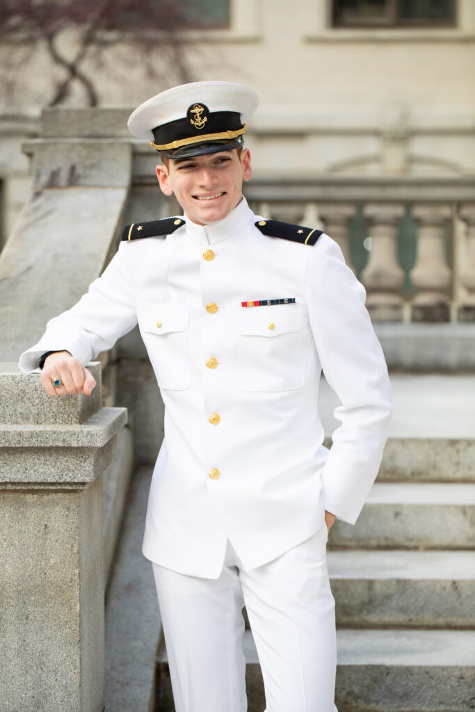 Naval Officer in choker white uniform smiles at in Annapolis.