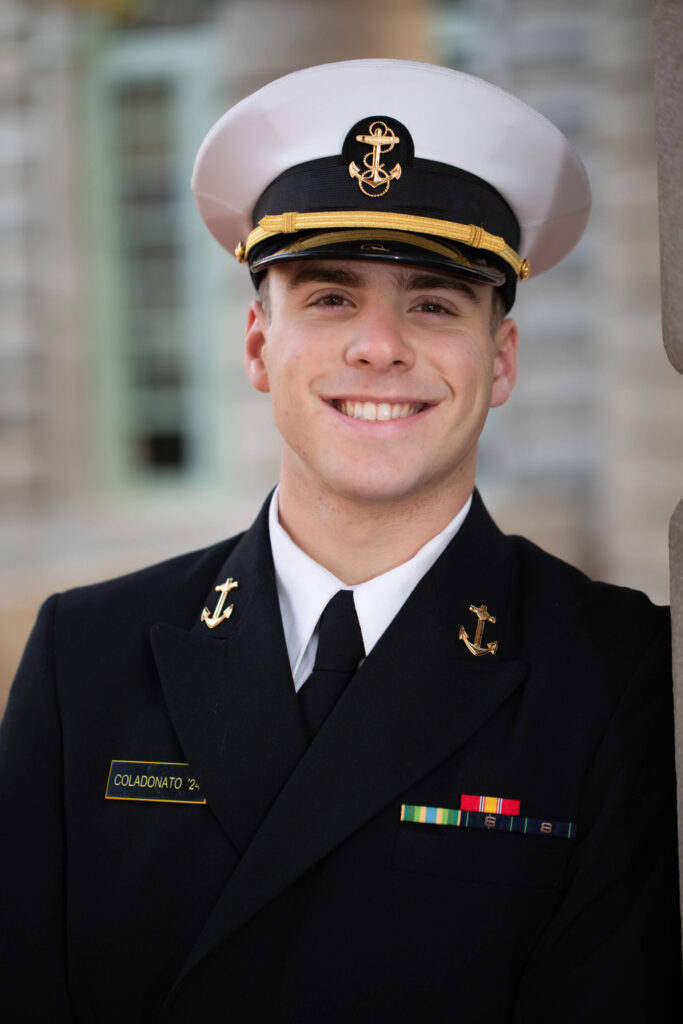 Midshipman dress blue uniform smiles for photography session in Annapolis Maryland.