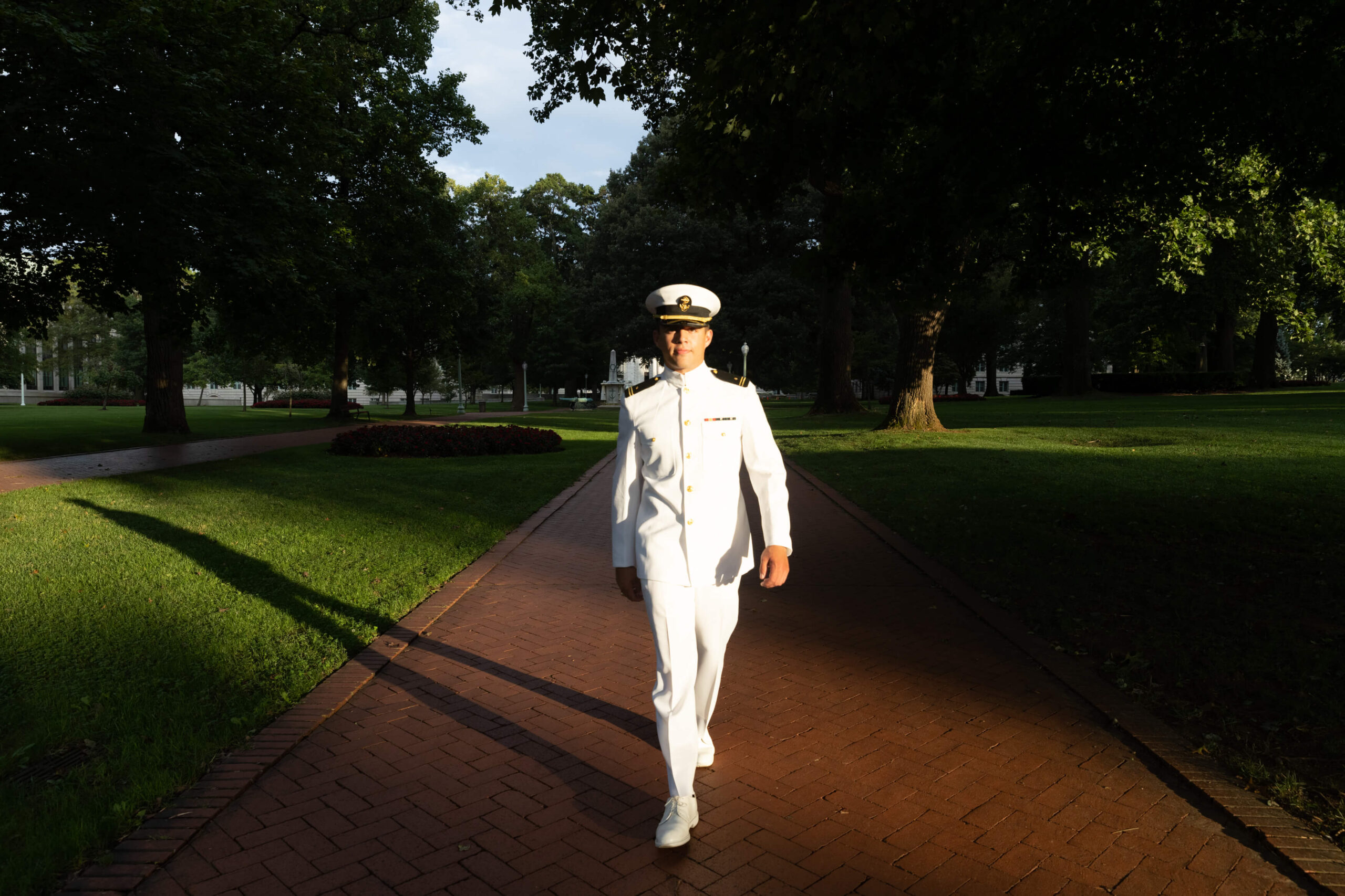 Naval Officer struts on Stribling walk in Navy choker white uniform.