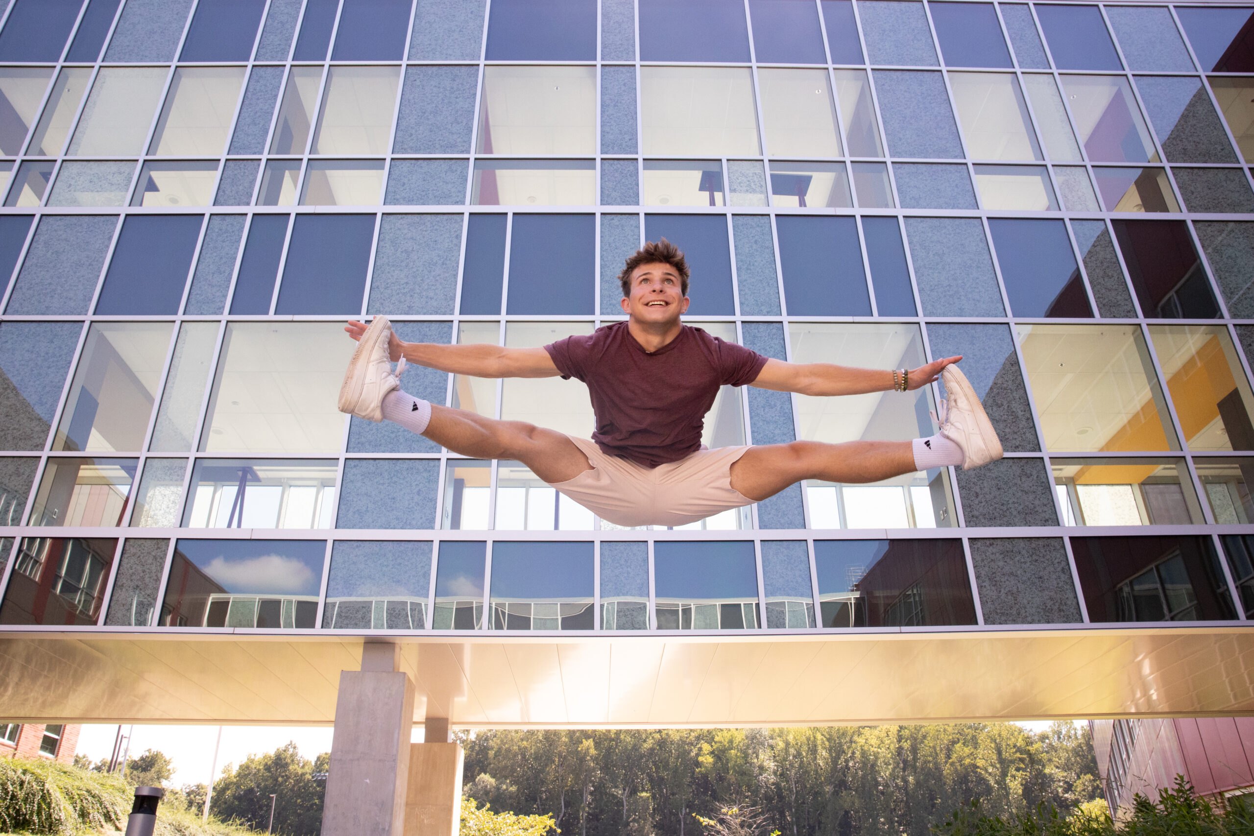 High School Senior photography In Maryland boy performs toe touch near sky bridge walking bridges By Kelly Eskelsen