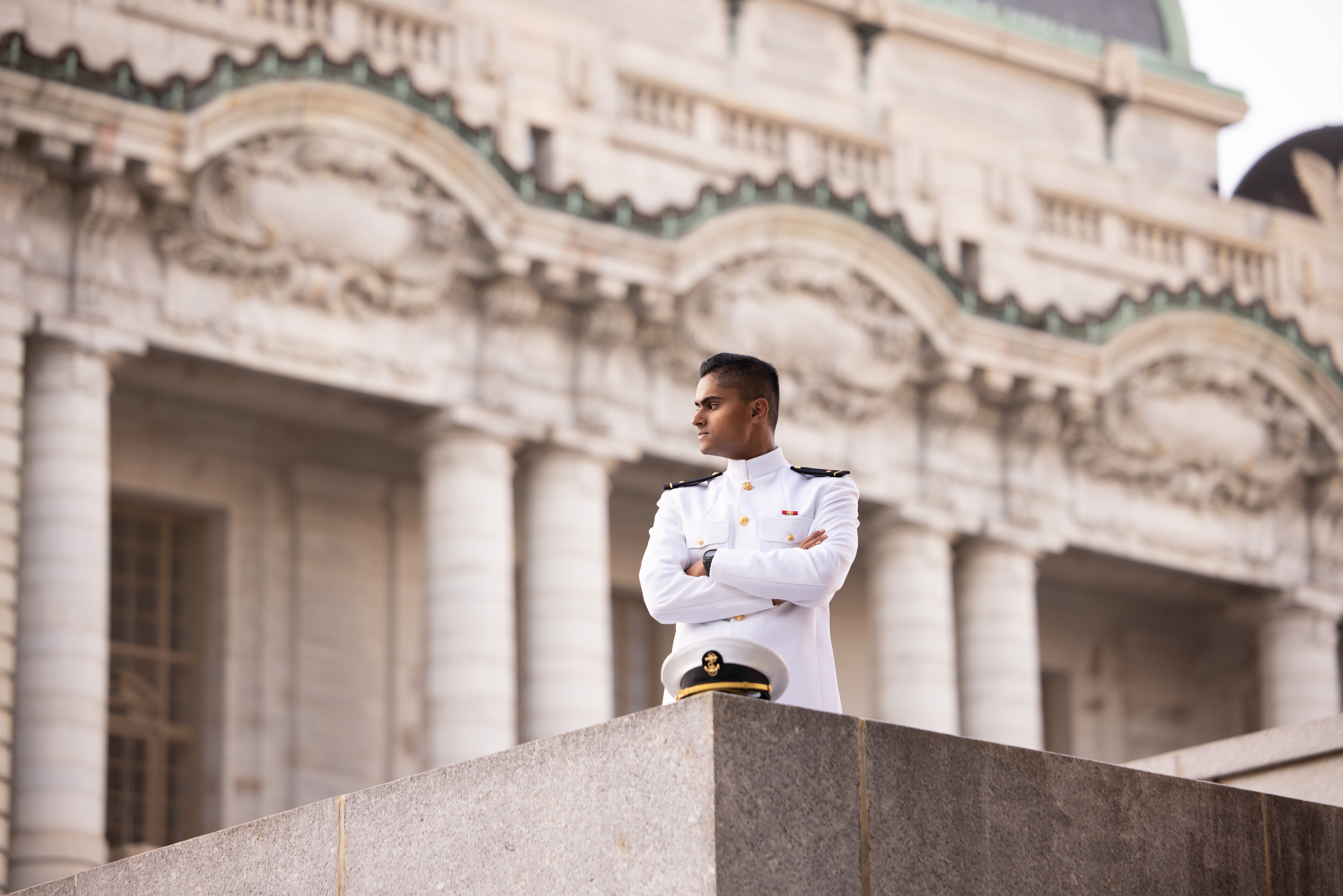 USNA Midshipment in Choker white uniform behind Bancroft Hall